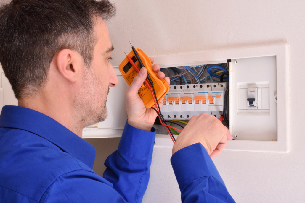 Electrician doing repairs in electrical housing box