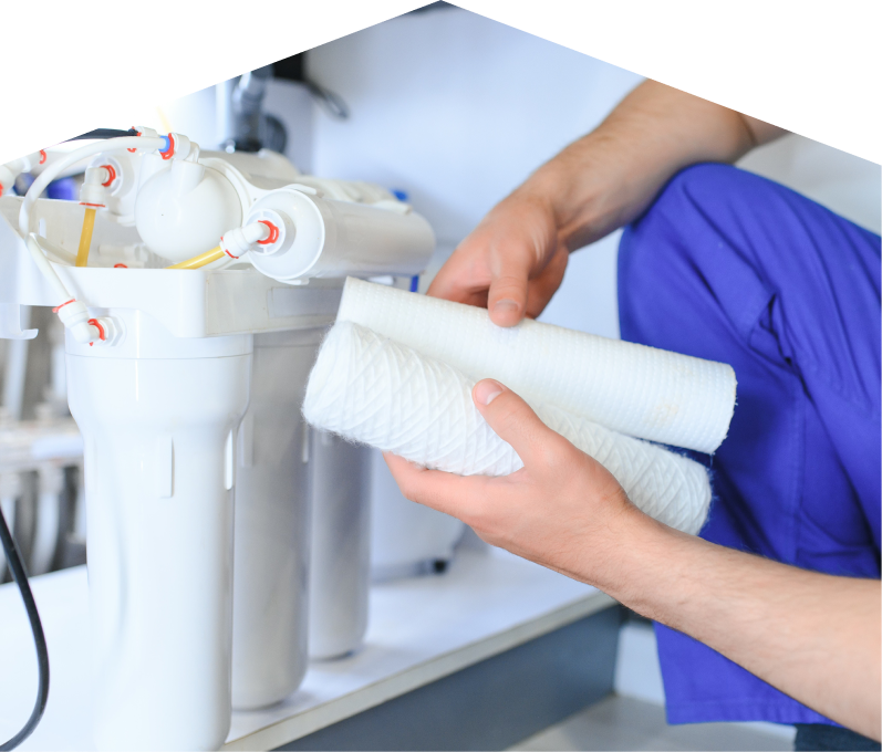 Dunn water filtration specialist replacing filter cartridges on a reverse osmosis water system installed under a sink. Dunn water filtration specialist replacing filter cartridges on a reverse osmosis water system installed under a sink.